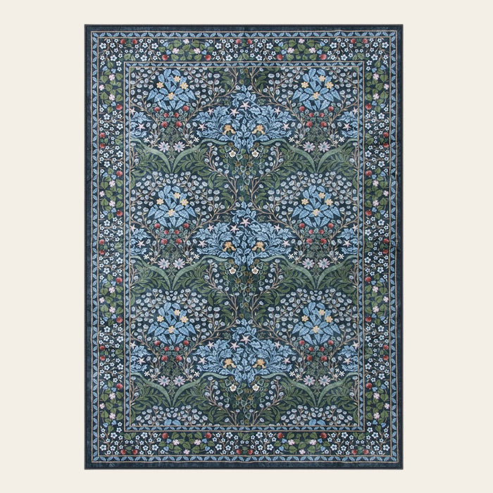 Covaba maximalism vintage french floral area rug in stormy blue, shown flat on a plain ivory backdrop