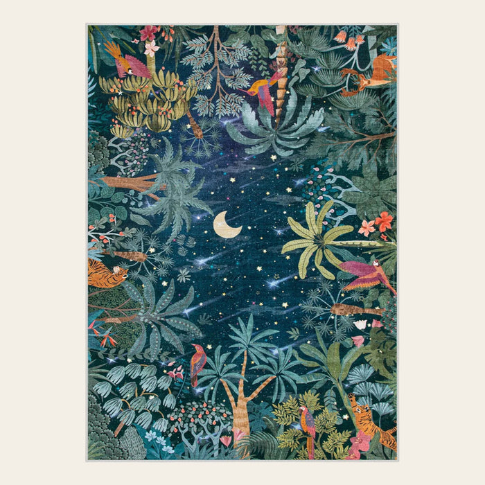 Covaba jungle midnight area rug in stormy blue, shown flat on a plain ivory backdrop