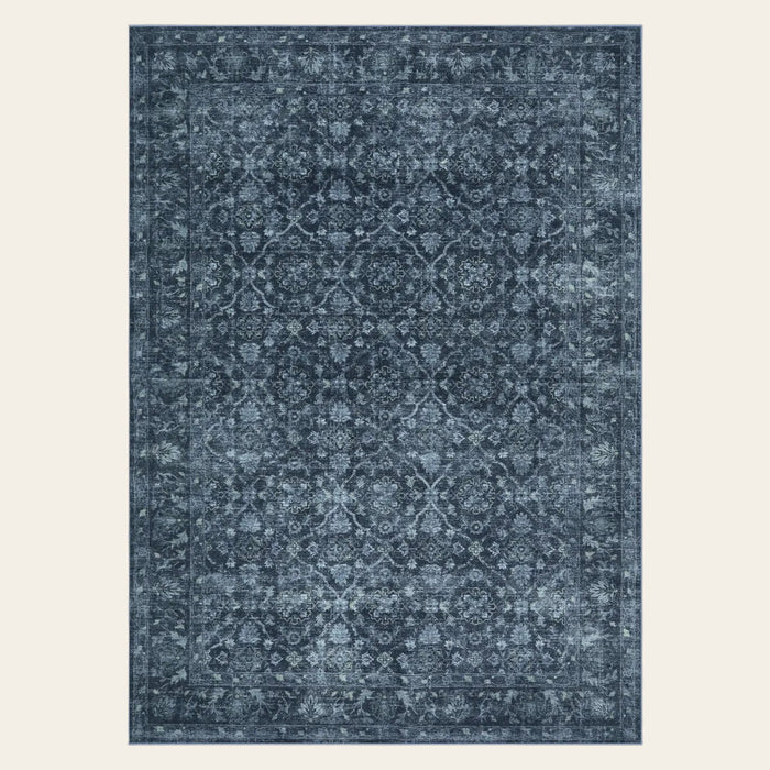 Covaba vintage persian distressed area rug in stormy blue, shown flat on a plain ivory backdrop