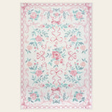 Covaba floral bows area rug in blush clay, shown flat on a plain ivory backdrop