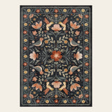 Covaba boho birdsong floral garden area rug in ink black, shown flat on a plain ivory backdrop