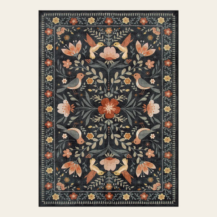 Covaba boho birdsong floral garden area rug in ink black, shown flat on a plain ivory backdrop