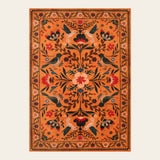 Covaba boho birdsong floral garden area rug in amber clay, shown flat on a plain ivory backdrop