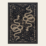Covaba mystical snake area rug in ink black, shown flat on a plain ivory backdrop