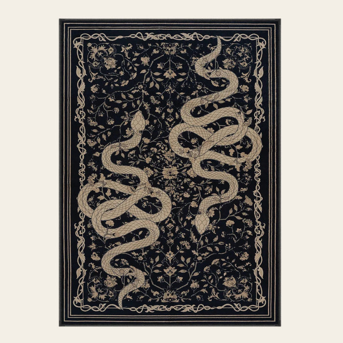 Covaba mystical snake area rug in ink black, shown flat on a plain ivory backdrop