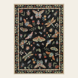 Covaba modern parisian insect area rug in ink black, shown flat on a plain ivory backdrop