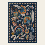 Covaba egyptian-inspired botanical area rug in deep navy, shown flat on a plain ivory backdrop