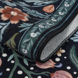 Covaba maximalism vibrant blossom floral rug in ink black, styled in a room setting