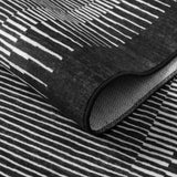 Covaba modern minimalist line rug in ink black, styled in a room setting