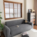 Stone Grey Chenille sofa cover draped over a three-seater sofa in a bright living room, view 5