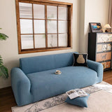 Stormy Blue Chenille sofa cover draped over a three-seater sofa in a bright living room