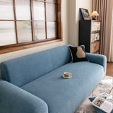 Stormy Blue Chenille sofa cover photographed at an angle beside a floor lamp