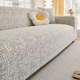 Stone Grey Jacquard sofa cover draped over a three-seater sofa in a bright living room, view 3