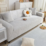Pearl Grey Palm Relief sofa cover draped over a three-seater sofa in a bright living room, view 2