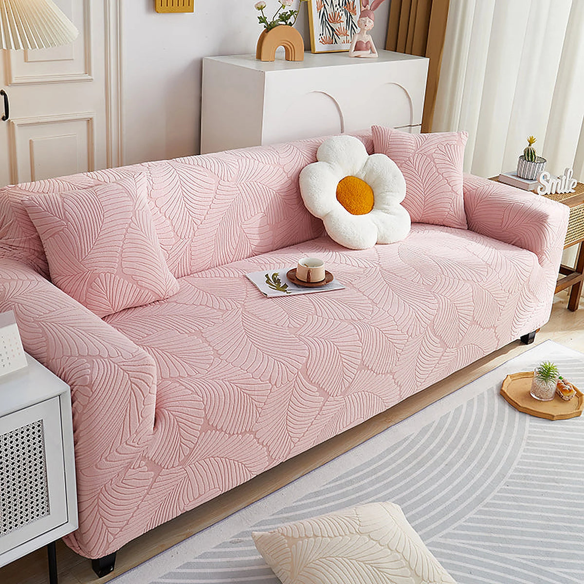 Pink Palm Relief sofa cover draped over a three-seater sofa in a bright living room, view 3