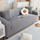 Stone Grey Palm Relief sofa cover draped over a three-seater sofa in a bright living room, view 4