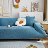 Stormy Blue Palm Relief sofa cover shown across the seat and backrest of a two-seater