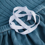 Stormy Blue Palm Relief sofa cover photographed at an angle beside a floor lamp