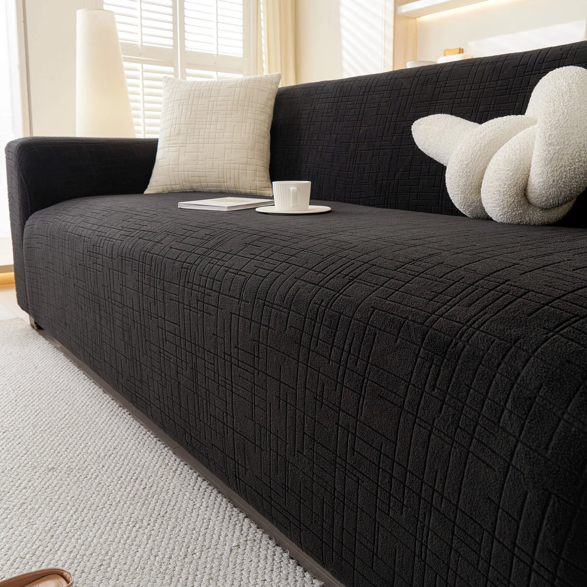 Ink Black Quilted Waffle sofa cover draped over a three-seater sofa in a bright living room, view 4