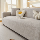 Pearl Grey Quilted Waffle sofa cover draped over a three-seater sofa in a bright living room, view 3