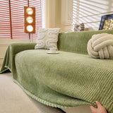 Sage Mist Corduroy sofa throw photographed at an angle beside a floor lamp, view 2