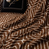 Auburn Brown Geometric Boho sofa throw covering the arm and seat of a sectional, view 2