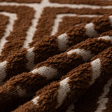 Auburn Brown Geometric Boho sofa throw spread across a sofa in daylight, view 2