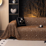 Auburn Brown Geometric Boho sofa throw shown on a straight sofa against a pale wall, view 2