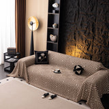 Warm Stone Geometric Boho sofa throw shown across the seat and backrest of a two-seater, view 5
