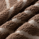Warm Stone Geometric Boho sofa throw shown on a straight sofa against a pale wall, view 5