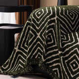 Forest Green Geometric Boho sofa throw shown on a straight sofa against a pale wall, view 4