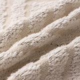 Ivory Cream Geometric Boho sofa throw spread across a sofa in daylight, view 3