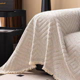 Ivory Cream Geometric Boho sofa throw shown on a straight sofa against a pale wall, view 3