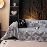 Pearl Grey Geometric Boho sofa throw draped over a three-seater sofa in a bright living room