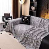 Pearl Grey Geometric Boho sofa throw covering the arm and seat of a sectional