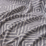 Pearl Grey Geometric Boho sofa throw spread across a sofa in daylight