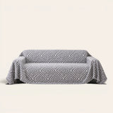 Pearl Grey Geometric Boho sofa throw on a plain studio background