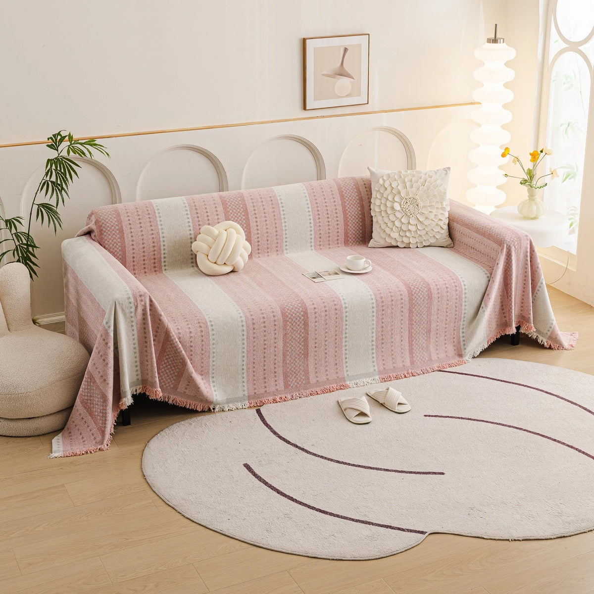 Blush Pink Metro Stripe sofa throw draped over a three-seater sofa in a bright living room, view 3