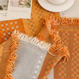 Orange Arrow Metro Stripe sofa throw photographed at an angle beside a floor lamp, view 3
