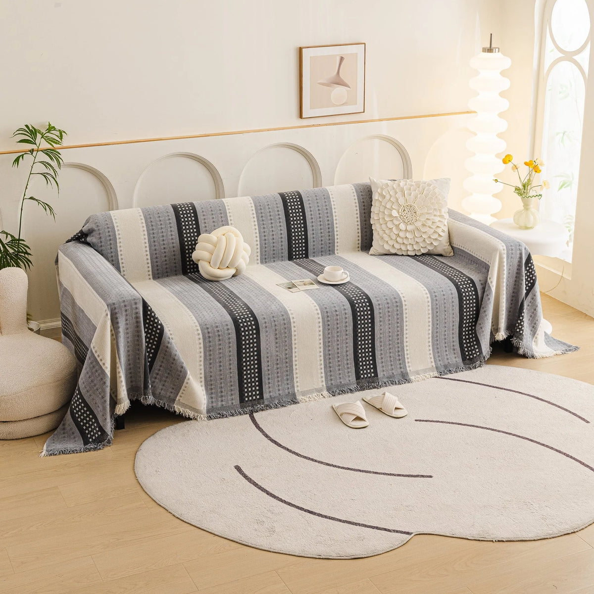 Pearl Grey Metro Stripe sofa throw draped over a three-seater sofa in a bright living room, view 2