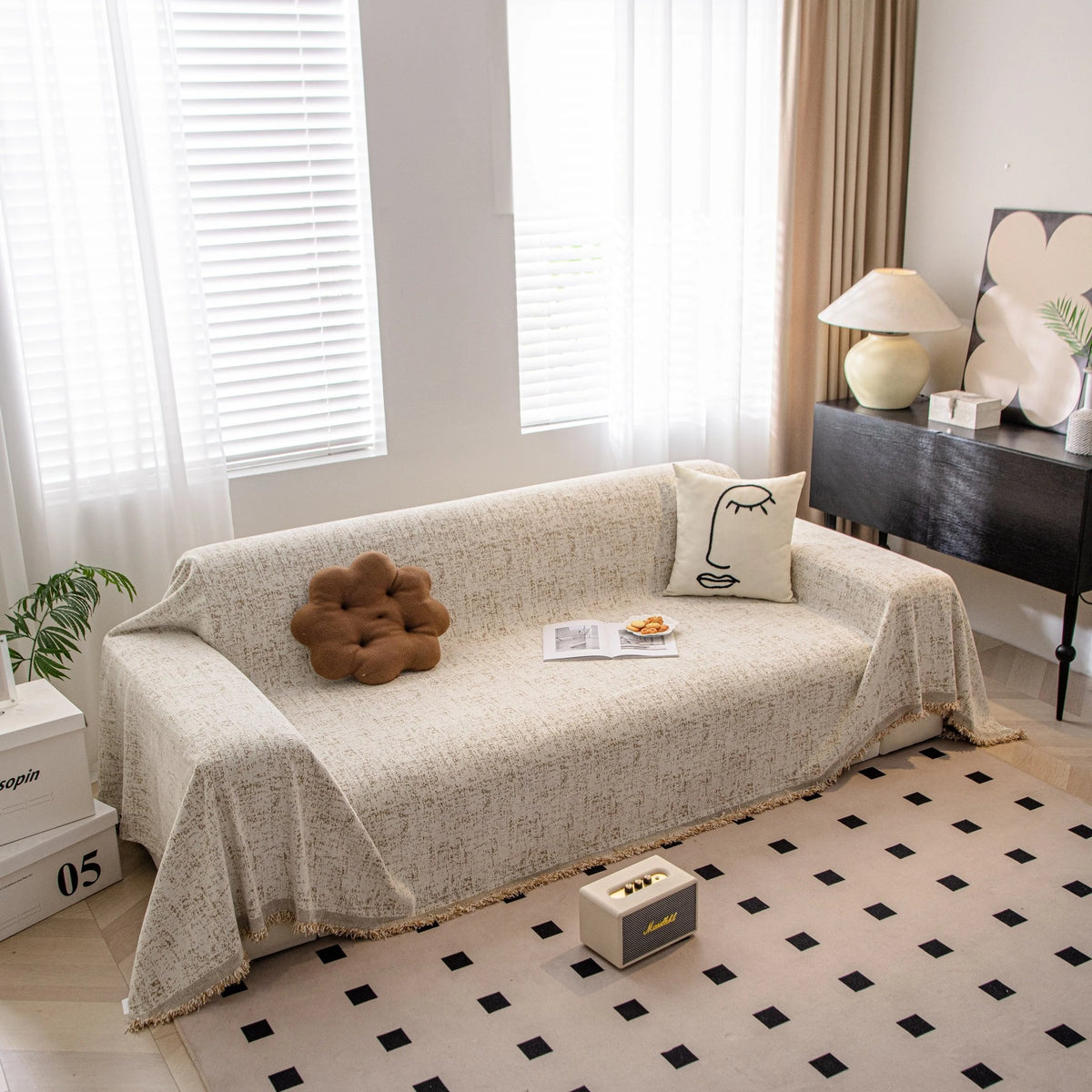 Boucle-Style Sand Spotted sofa throw draped over a three-seater sofa in a bright living room