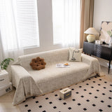 Boucle-Style Sand Spotted sofa throw draped over a three-seater sofa in a bright living room