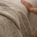 Boucle-Style Sand Spotted sofa throw covering the arm and seat of a sectional