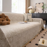 Boucle-Style Sand Spotted sofa throw photographed at an angle beside a floor lamp