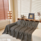 Charcoal Tweed Knit sofa throw draped over a three-seater sofa in a bright living room