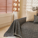 Charcoal Tweed Knit sofa throw styled with cushions on a low-back sofa