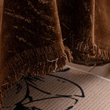 Auburn Brown Velvet Embossed sofa throw styled with cushions on a low-back sofa