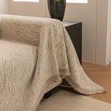 Boucle-Style Sand Wave Quilted sofa throw photographed at an angle beside a floor lamp, view 2