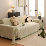 Lime Mist Wave Quilted sofa throw draped over a three-seater sofa in a bright living room