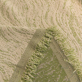 Lime Mist Wave Quilted sofa throw photographed at an angle beside a floor lamp